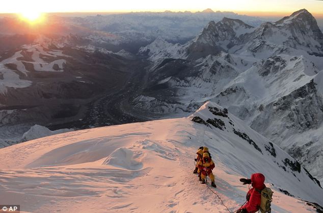 Sixty years: In this image released by mountain guide Adrian Ballinger of Alpenglow Expeditions and taken at sunrise on Saturday, May 18, 2013, climbers make their way to the summit of Mount Everest